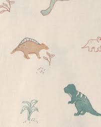 Primer plano del estampado de dinosaurios en colores tierra y verde sobre fondo crema, parte del