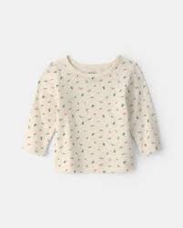 Camiseta de manga larga en color crema con estampado de pequeños dinosaurios en tonos verdes y
