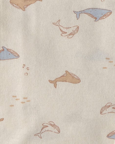 Detalle de una manta recibidora Carter's con un tierno estampado de ballenas y pequeños peces en