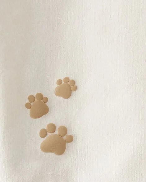 Huellas de patita en relieve sobre el sudadero crema del conjunto Carters para niño.