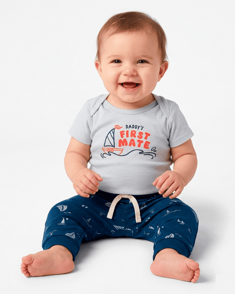 Bebé feliz usando conjunto Carter's náutico de body "First Mate" y pantalón azul.
