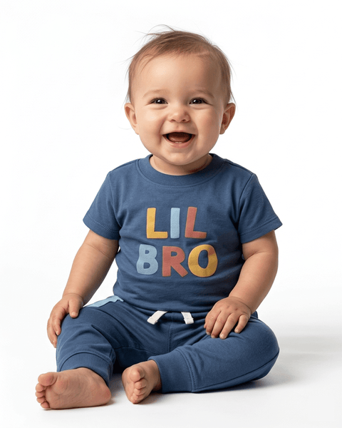 Bebé sonriente vistiendo conjunto Carter's "LIL BRO" azul con body y pantalón cómodo.