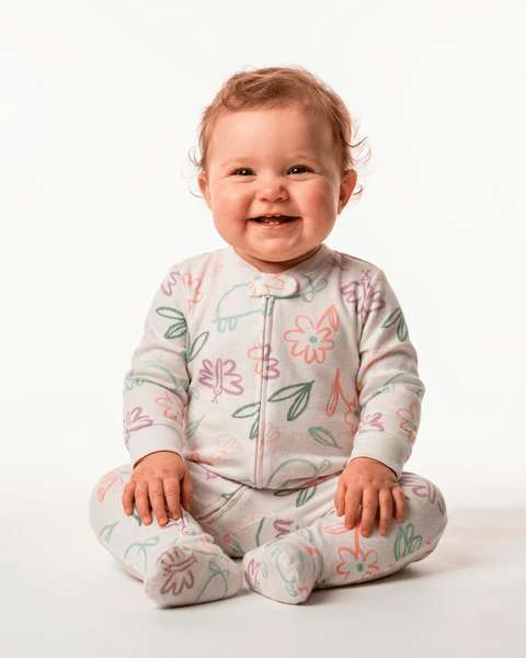 Bebé feliz con pijama enteriza Carter's de algodón blanco, estampado floral y de animales, cómoda.