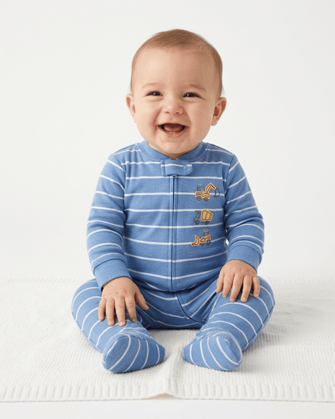 Bebé sonriente vistiendo pijama enteriza de algodón Carter's con rayas azules y camiones.