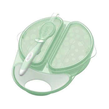 Plato y cuchara de viaje verde translúcido con tapa, compartimentos y asa, ideal para alimentación de bebé.