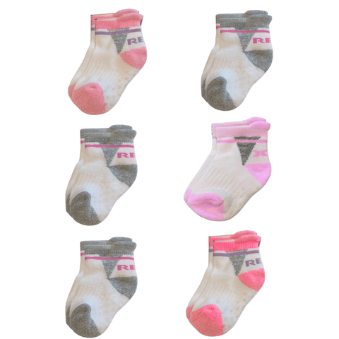 Set de 6 pares de calcetas antideslizantes para niña, en blanco con detalles rosados y grises.