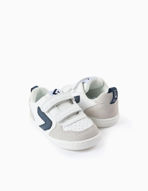 Tenis Zippy blancos y azules con velcro para niño, vista lateral. Diseño moderno y suela cómoda.