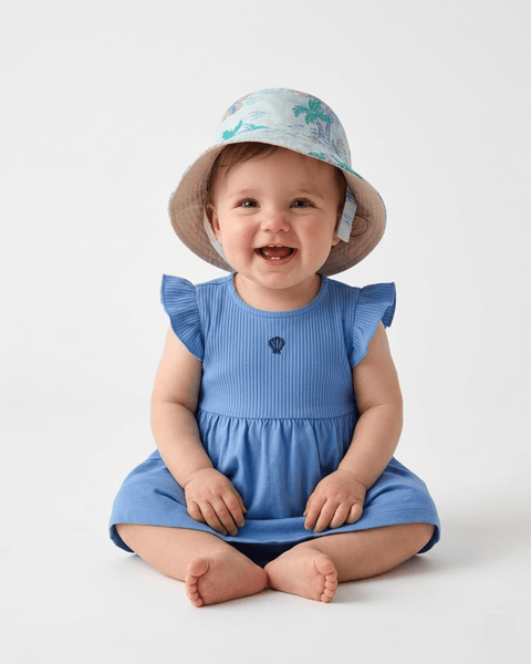 Bebé sonriente usando el sombrero de playa reversible Carter's, ideal para proteger del sol.