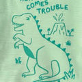 Detalle de playera verde Carter's con dinosaurio y frase 'HERE COMES TROUBLE'.