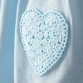 Detalle de corazón crochet celeste bordado en el bolsillo del enterizo Carter's para bebé.