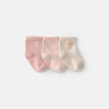 Set de 3 calcetines para bebé niña Carter's en rosa liso, rayas y crema con flor bordada. Con suelas antideslizantes para seguridad.
