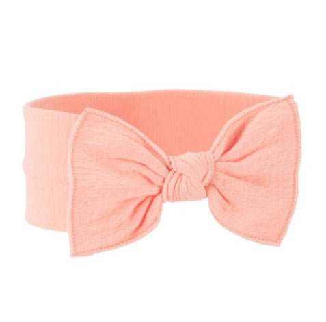 Diadema para bebé Oshkosh rosada con lazo grande, tela suave y texturizada, ideal para niñas.